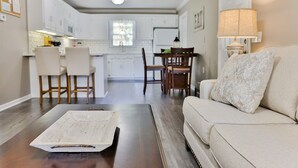 A modern living room with a sofa, a coffee table, and a dining area in the background. - 2 King Bed Master Suites and 1/2 Mile from Chief  Ladiga Trails and Elwell Park (Weaver)