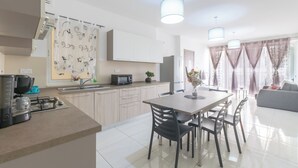 A modern kitchen with a dining area, a coffee machine, and a refrigerator. - ★★Modern And Cozy Apartment ,Close to The Sea ★★3 (San Pawl il-Baħar, Malta)
