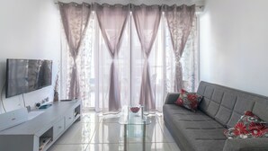 A modern living room with a flat-screen TV, a glass coffee table, a grey sofa with floral cushions, and sheer curtains. - ★★Modern And Cozy Apartment ,Close to The Sea ★★3 (San Pawl il-Baħar, Malta)