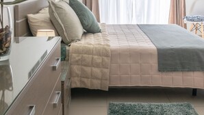 A bedroom with a bed, bedside table, lamp, air conditioning unit, curtains, and a plant. - ★ Penthouse w/ SEA VIEW in St. pauls bay ★ (San Pawl il-Baħar, Malta)