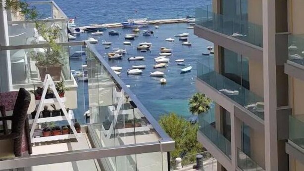 A high-rise building with a glass balcony overlooking a marina with boats. - ★ Penthouse w/ SEA VIEW in St. pauls bay ★ (San Pawl il-Baħar, Malta)