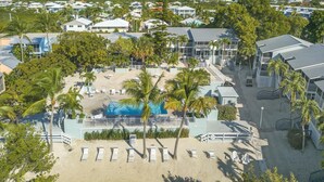 An aerial view of a resort with multiple buildings, a pool area, and a beach with sun loungers. - Overlooking the Lagoon and Pool (Key Largo)