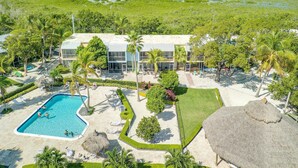 A resort with a swimming pool, multiple guest rooms, and a view of a mangrove area. - Overlooking the Lagoon and Pool (Key Largo)