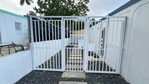 A gated area with a concrete pathway leading to a building entrance. - Ocean Side PR (Carolina)