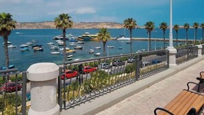 A coastal promenade with a view of the sea, parked cars, and a row of palm trees. - ☆☆Amazing Apartment w/side sea view☆☆ 1 (St. Pauls Bay, Malta)