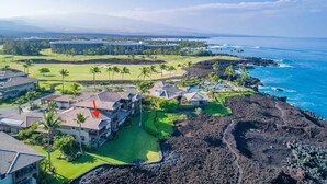 Una località balneare con diversi edifici, un campo da golf e vista sull'oceano.