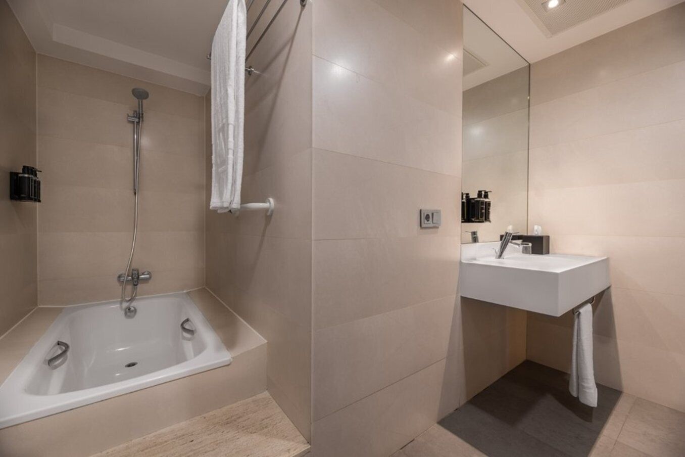 A modern bathroom with a bathtub, a shower, and a sink.