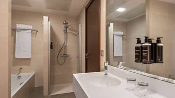 Un baño moderno con un espejo grande, ducha y bañera.