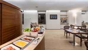 Un comedor moderno con mesas de buffet, paneles de madera y un diseño limpio y minimalista.