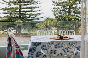 A table set for two with a floral tablecloth, two glasses of champagne, and a plate of food.