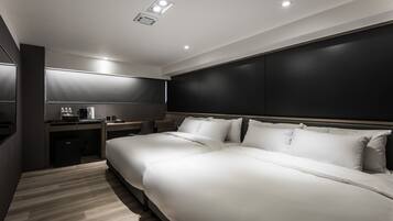 A modern hotel room with a large bed, a desk, and a chair.