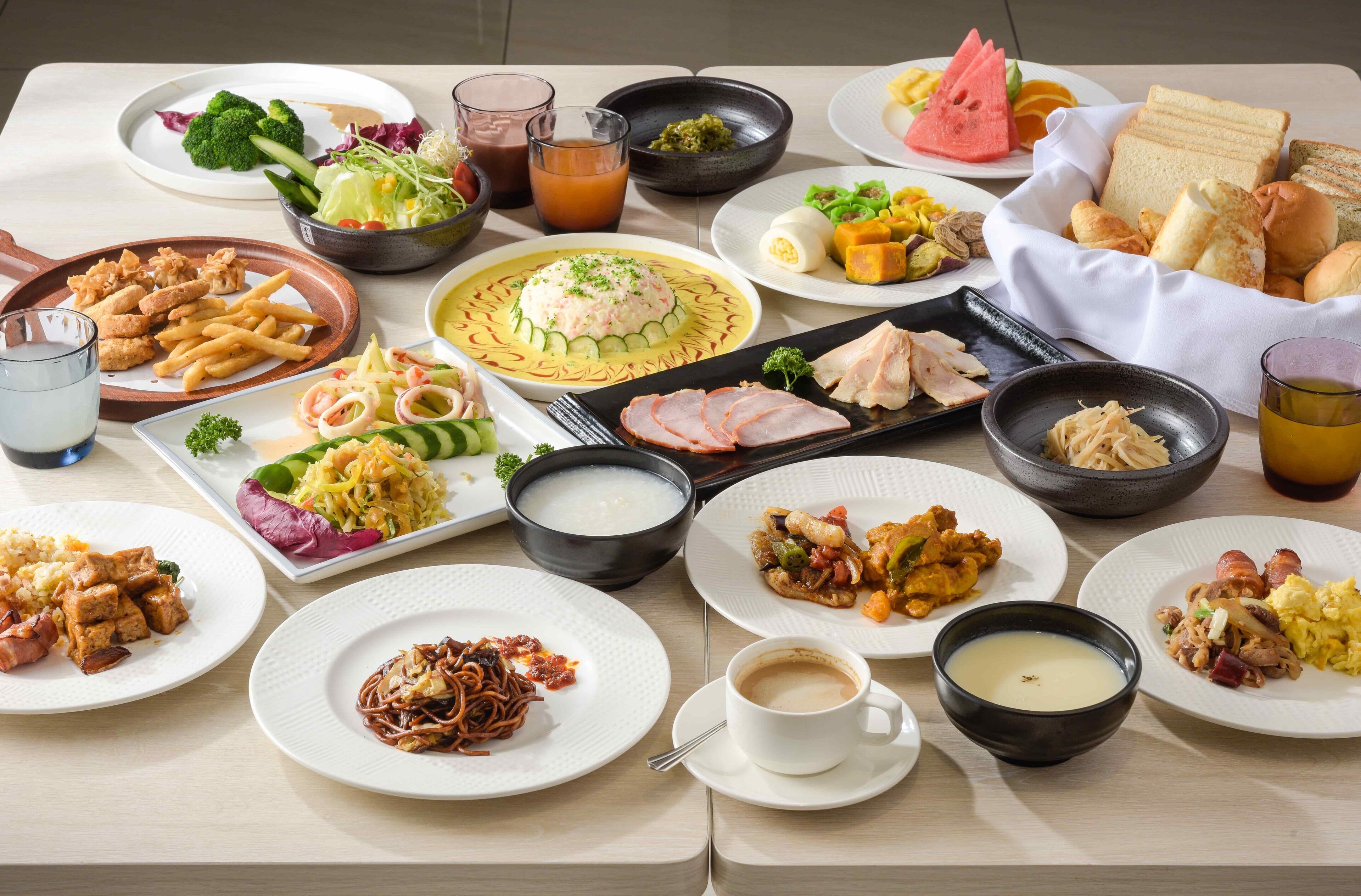 Una mesa con varios platos, incluyendo sushi, fideos y un tazón de sopa.