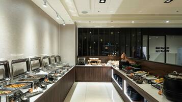 A buffet with multiple food stations, a coffee bar, and a counter with a coffee machine.