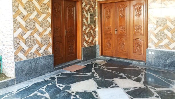 A hallway with two wooden doors, patterned walls, and a marble floor. - C4 Mirpur City AJK Overseas Pakistanis Villa 3bed Guesthouse (Mirpur city AJK)