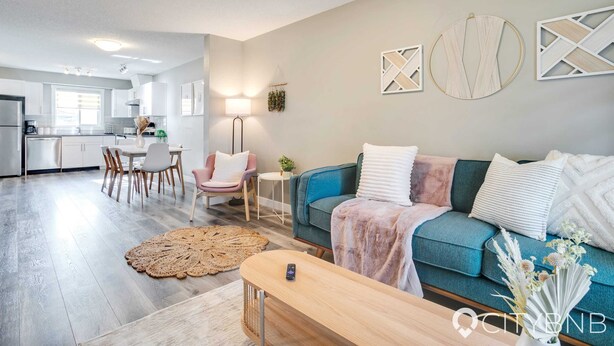 Ein modernes Wohnzimmer mit einer Couch, einem Couchtisch und einem Essbereich mit Stühlen.