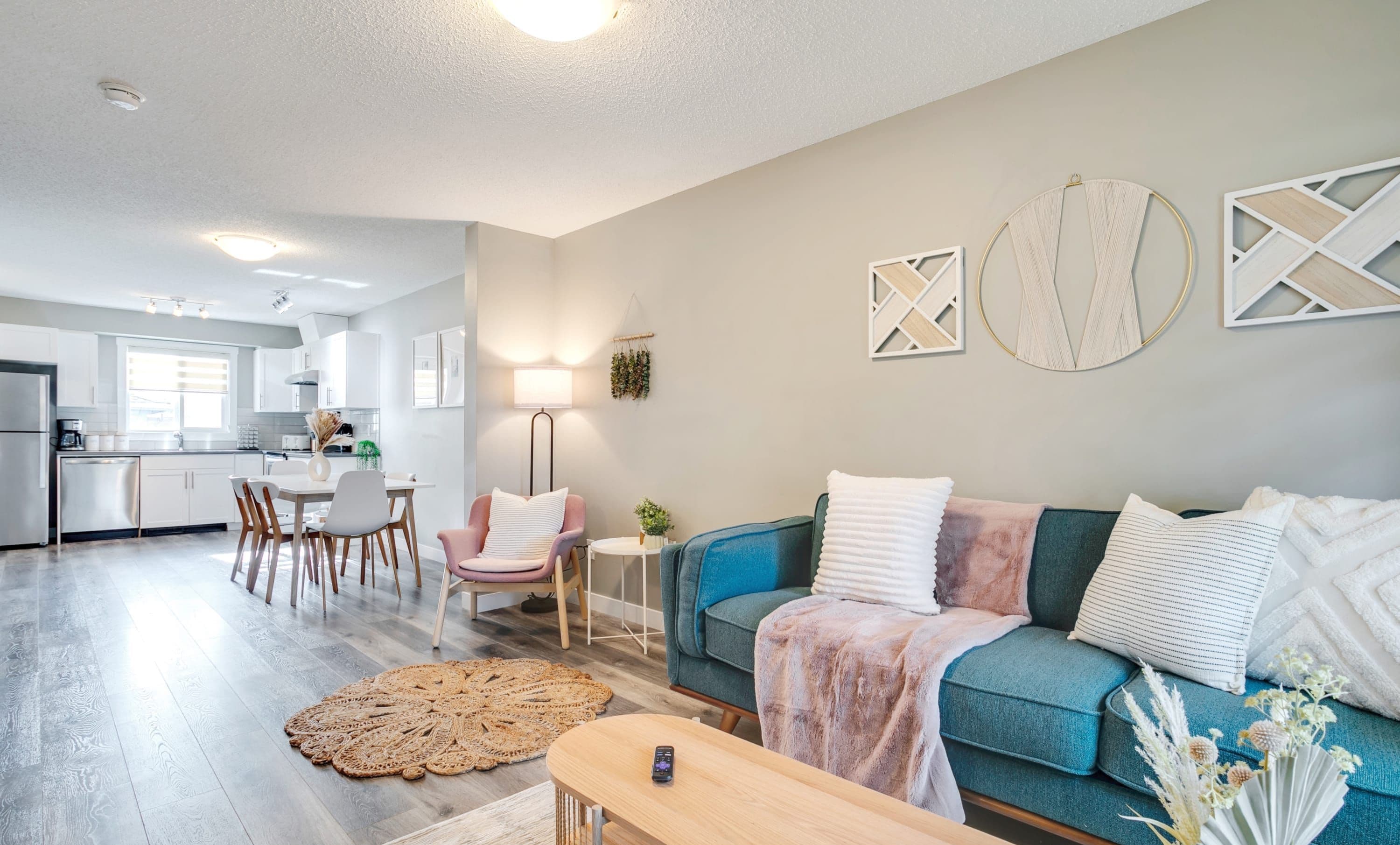 Uma sala de estar moderna com sofá, mesa de centro e área de jantar com cadeiras.