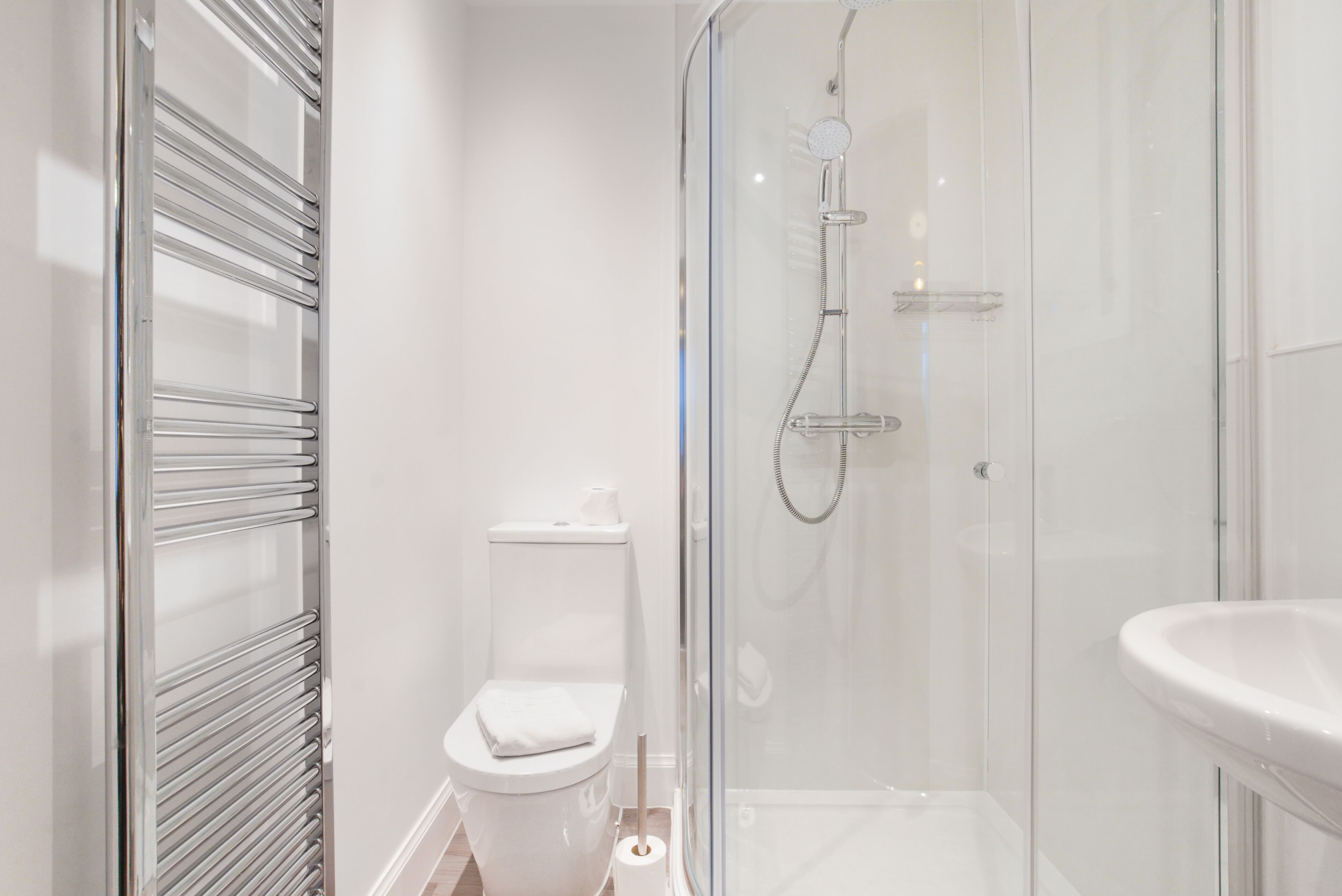 Un baño moderno con cabina de ducha de vidrio, inodoro y lavamanos.