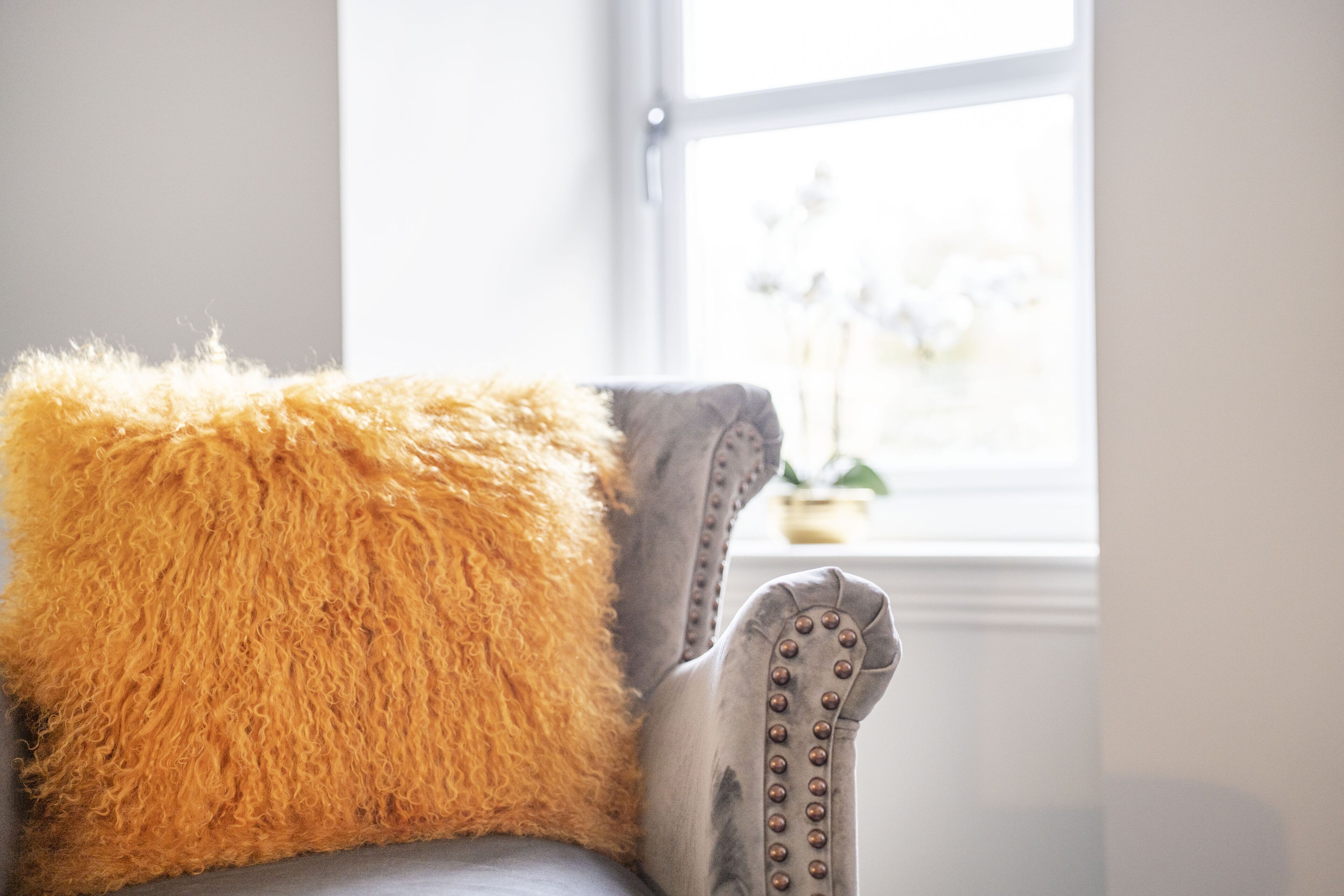 Une chaise dotée d’un coussin moelleux de couleur orange et d’un accoudoir décoratif.