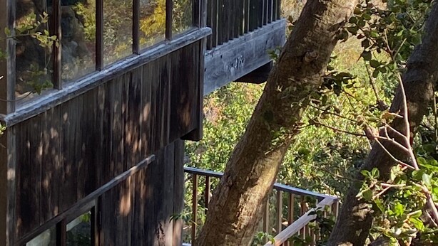 Una terraza de madera con cerramiento de vidrio que ofrece vistas panorámicas.