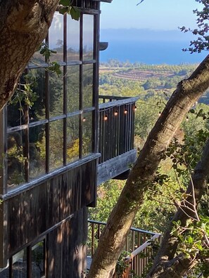 A wooden deck with a glass enclosure overlooking a scenic landscape.