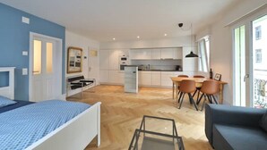 Un apartamento moderno con un dormitorio, comedor y cocina.