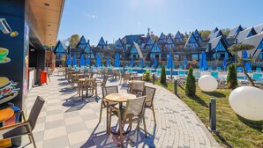 Un complexe hôtelier doté d’un espace extérieur aménagé, d’une piscine et de bâtiments de style chalet.