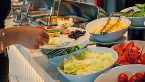 Un buffet proposant divers plats, avec un réfrigérateur Coca-Cola en arrière-plan.