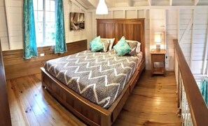 Quarto com estrutura de madeira, cama, cortinas e mesa de cabeceira.