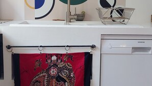 A kitchen with a modern faucet, a Siemens dishwasher, and a colorful abstract painting on the wall. - Magnifique Villa Provençale Entre Golfe de St Tropez et Verdon (Vidauban)