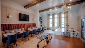 A modern dining area with a wooden dining table, blue chairs, and a red upholstered bench. - Comfy Cottage (Mobile)