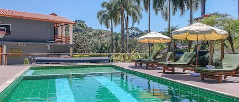 Una piscina al aire libre, camas de piscina gratis, sombrillas