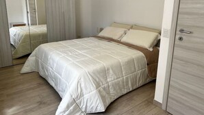 Un dormitorio con cama, espejo y armario.