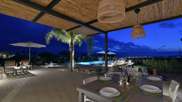 An outdoor dining area with a table set for two, surrounded by chairs, and a pool in the background. - VILLA RARIKI, POOL AND RELAX (Scicli)