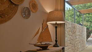 A model sailboat on a wooden table, a lamp, and woven wall decorations. - VILLA RARIKI, POOL AND RELAX (Scicli)