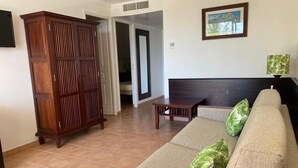 Uma sala de estar com um sofá, um armário de madeira e um quadro na parede.