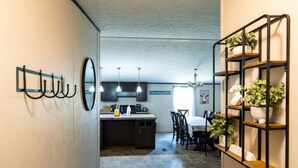 Une cuisine moderne avec des meubles de couleur sombre, un îlot central et des luminaires suspendus.