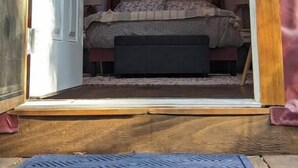 Un cuarto acogedor y circular con cama y un pequeño banco, decorado con luces de adorno.