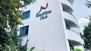 A modern building with a curved facade and the sign "Hautilus Club" on the side.