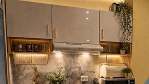 A modern kitchen with a built-in microwave, a sink, and a countertop with a marble backsplash.