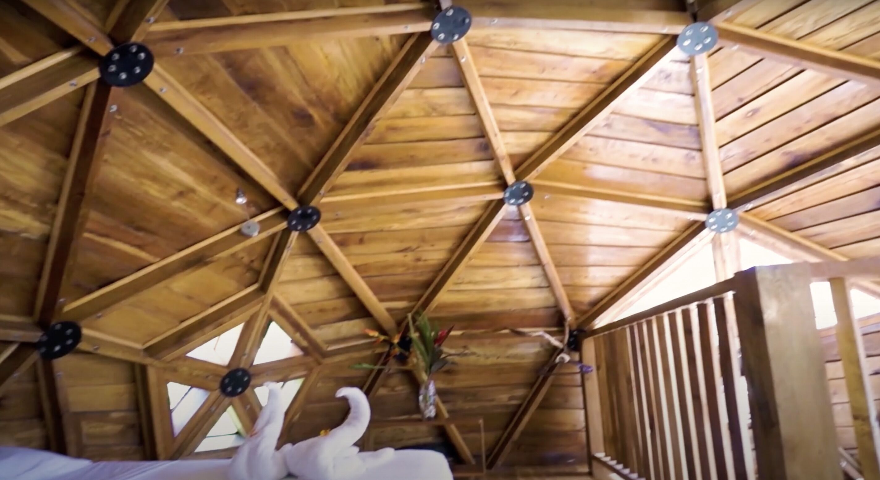 Techo de madera con un diseño geométrico y una columna central.