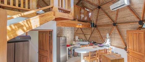 A spacious kitchen with wooden cabinets, a refrigerator, and a dining area with a table and chairs.