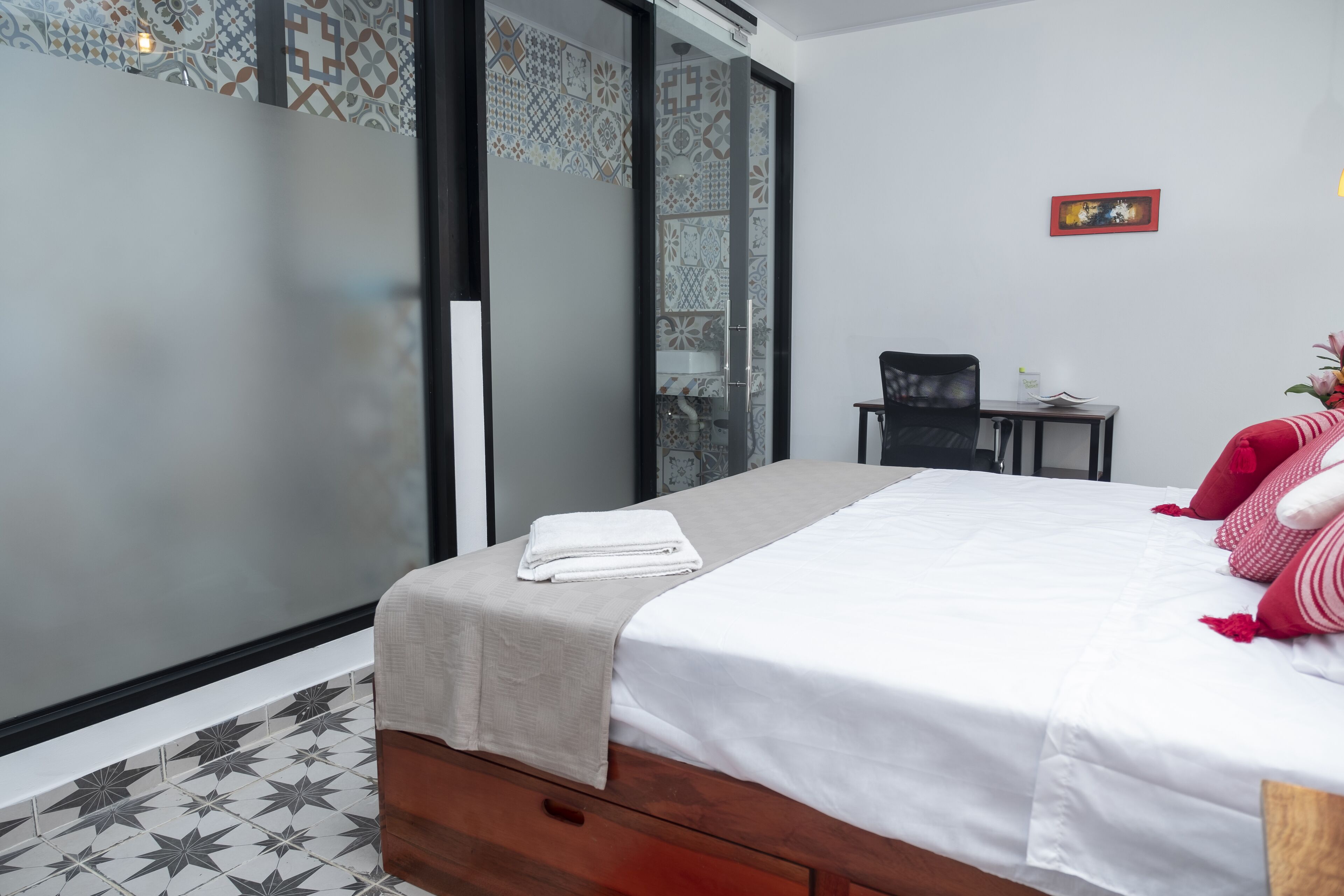 Een moderne hotelkamer met een bed, een klein bureau en een stoel.