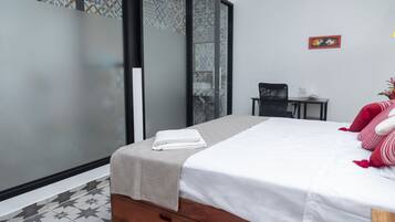 Een moderne hotelkamer met een bed, een klein bureau en een stoel.
