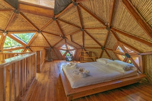 A wooden interior with a bed, wooden railings, and a fan. - Seacret Villa (Cóbano)