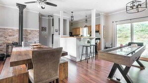 Una cucina moderna con isola centrale, pavimento in legno e illuminazione a sospensione.