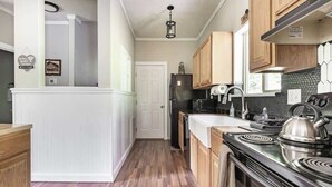 Una cucina con mobili in legno, un piano cottura nero e un frigorifero.
