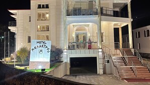 Un hôtel à plusieurs étages doté d’un balcon, d’un escalier et d’une enseigne.