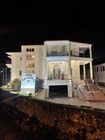 Un hotel de varios pisos con balcón, una escalera y un cartel.