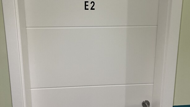 A white door with the label "E2" and a keyhole lock. - Pension Waldau (Kassel)