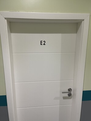 A white door with the label "E2" and a keyhole lock. - Pension Waldau (Kassel)